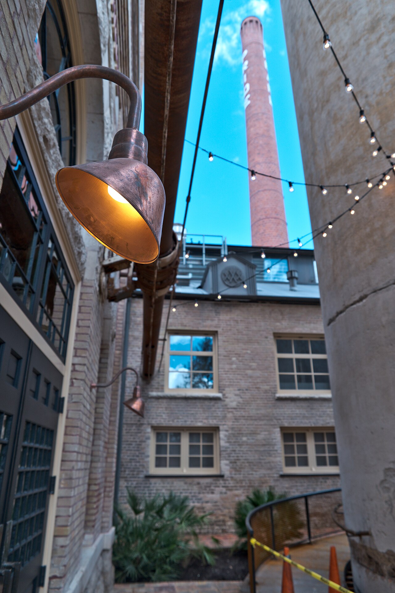 The historic Pearl brewery smokestack and string lights at dusk