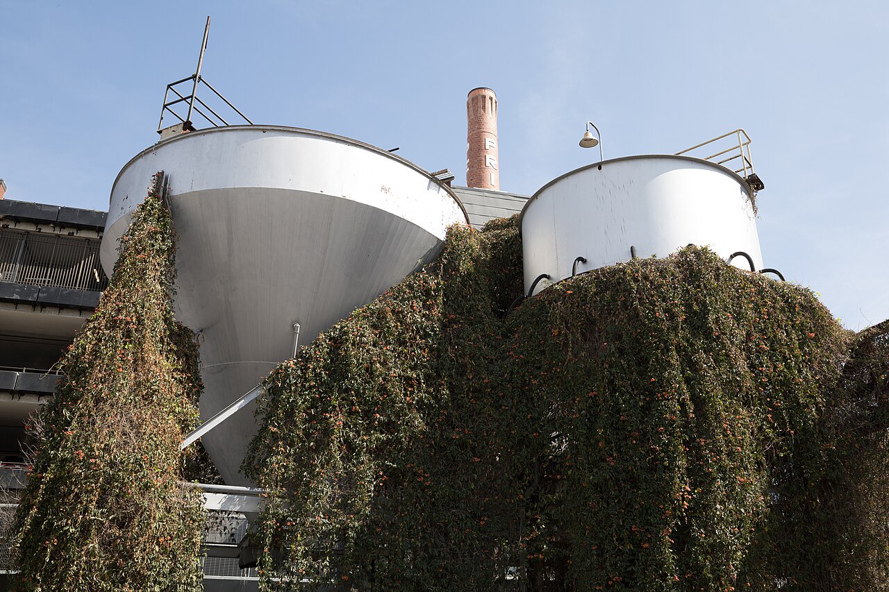 Ivy-draped fermenting tanks beneath the PEARL smokestack